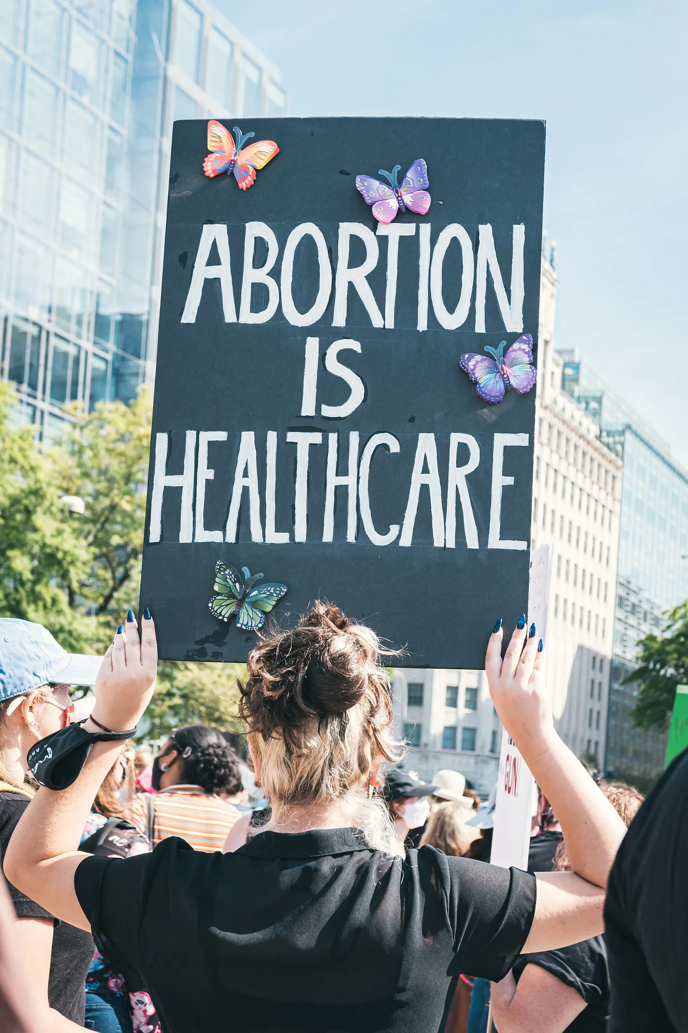 a woman holding a sign saying "abortion is healthcare"